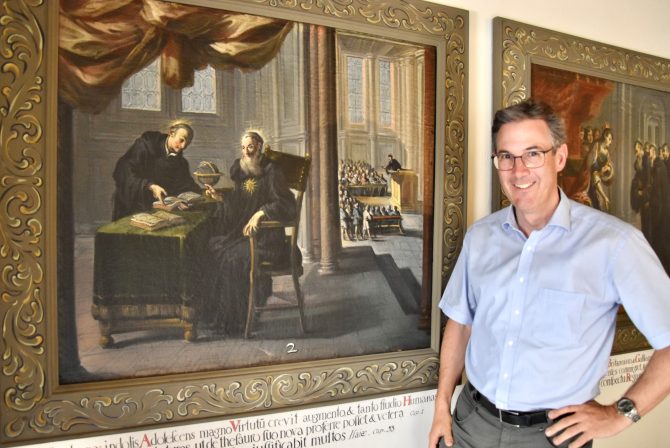 Dompfarrer Beat Grögli in der Galluskapelle neben dem Bild, das Gallus (links) zusammen mit Kolumban, seinem Meister, zeigt. Bild: Roger Fuchs